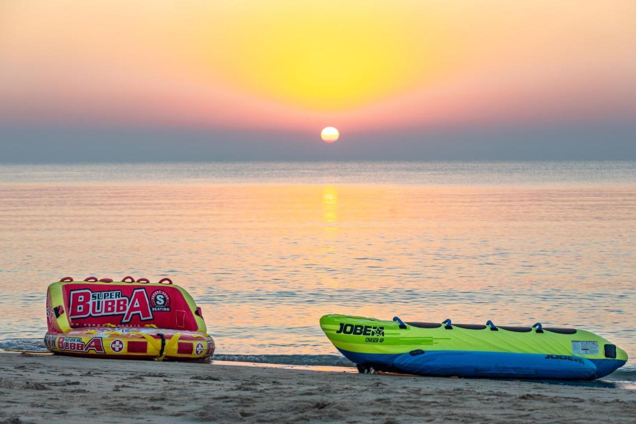 Sealine Beach, A Murwab Resort Mesaieed Exterior photo Sunset at the beach
